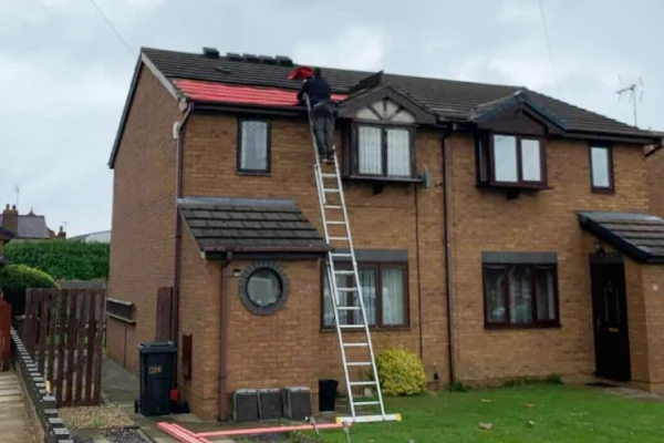 Roofing Contractor on a ladder fixing roof