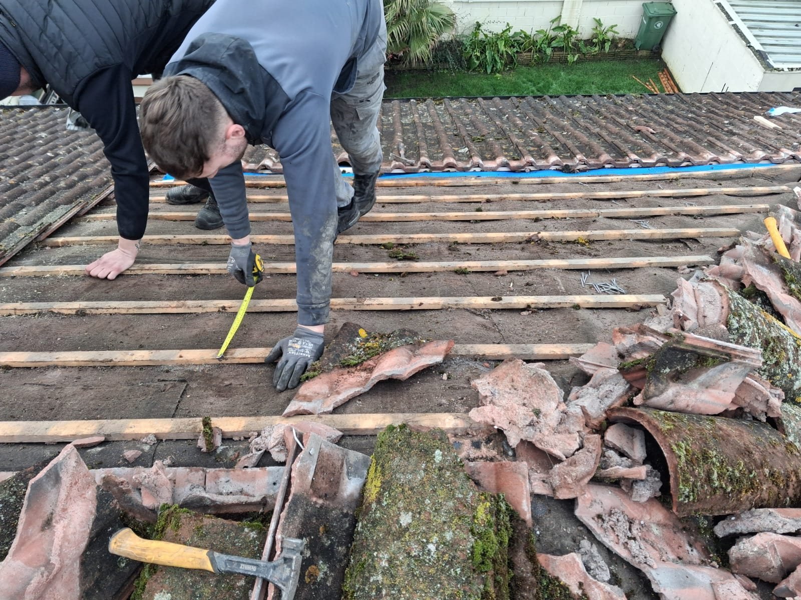 Roofer measuring battens during a roof repair in Dublin