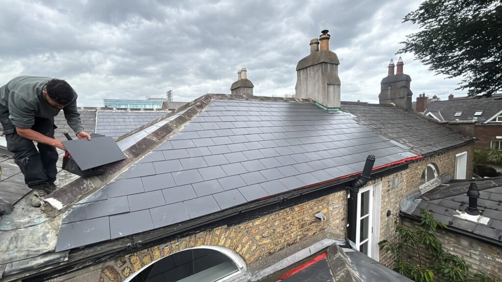 Roofer laying new slates on a Dublin roof