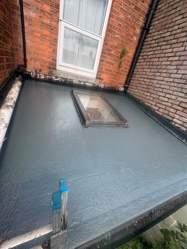 Finished flat roof with liquid waterproofing around a roof light